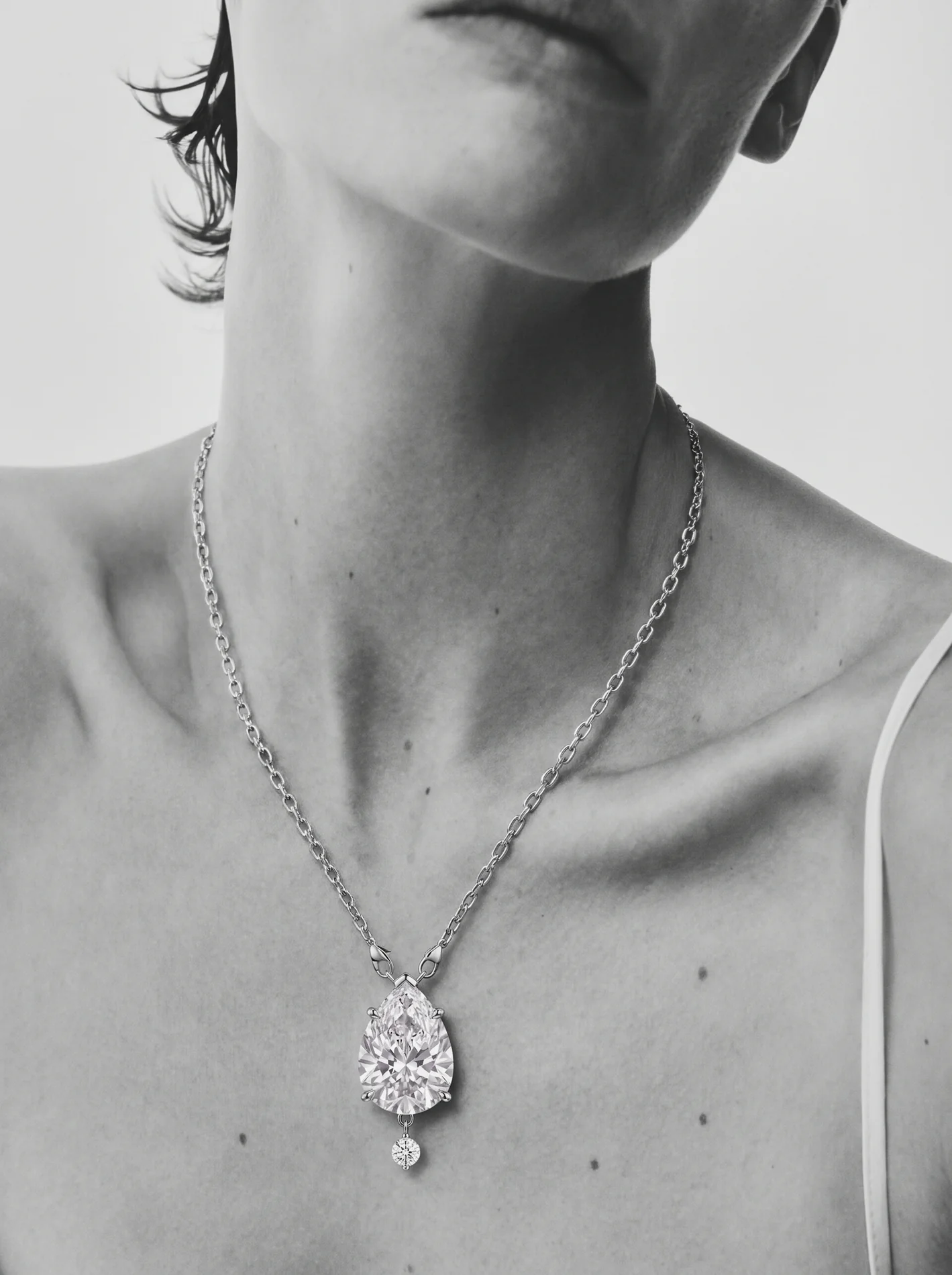 The family pear pendant worn at the collarbone.