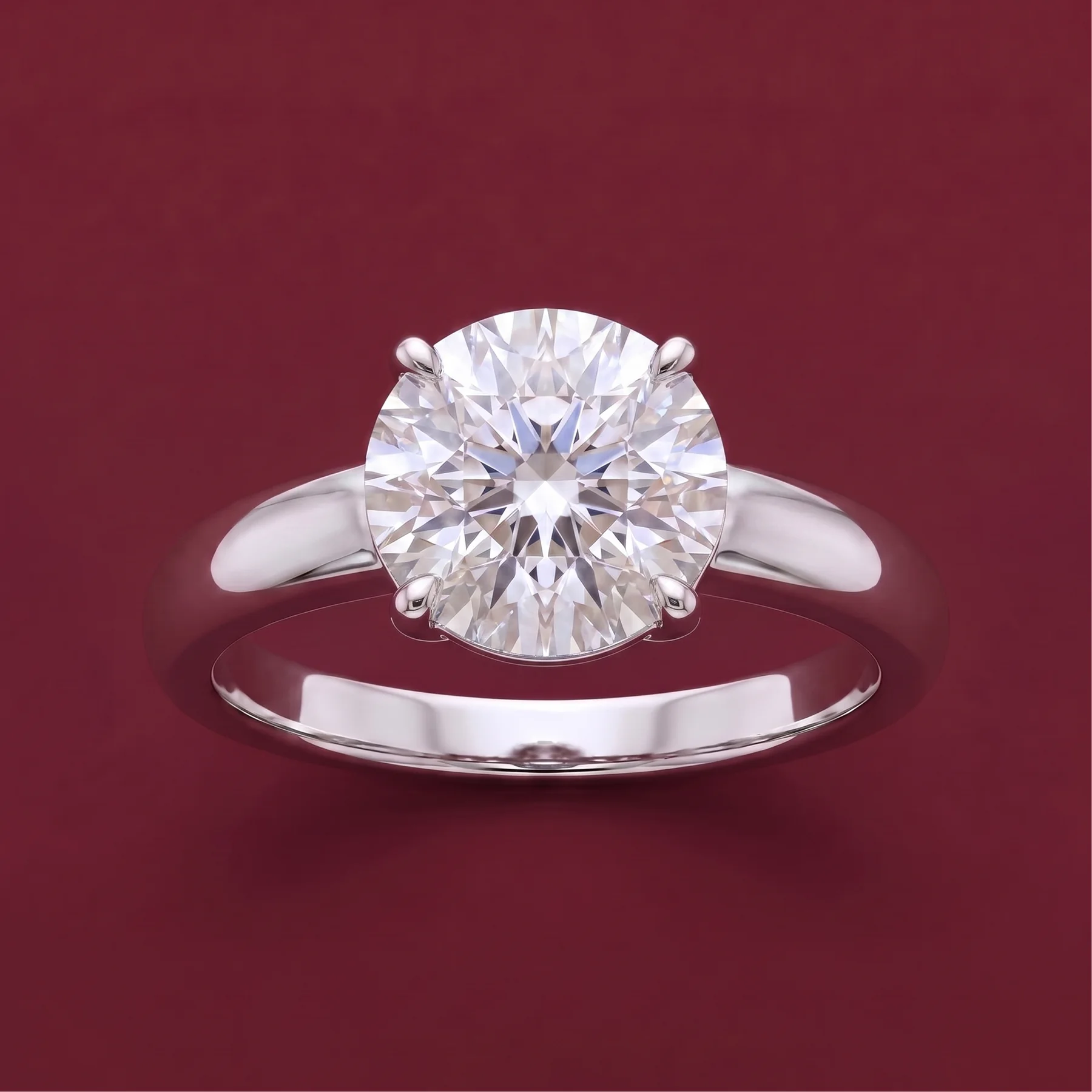 A warm-gold legacy solitaire ring on burgundy velvet.